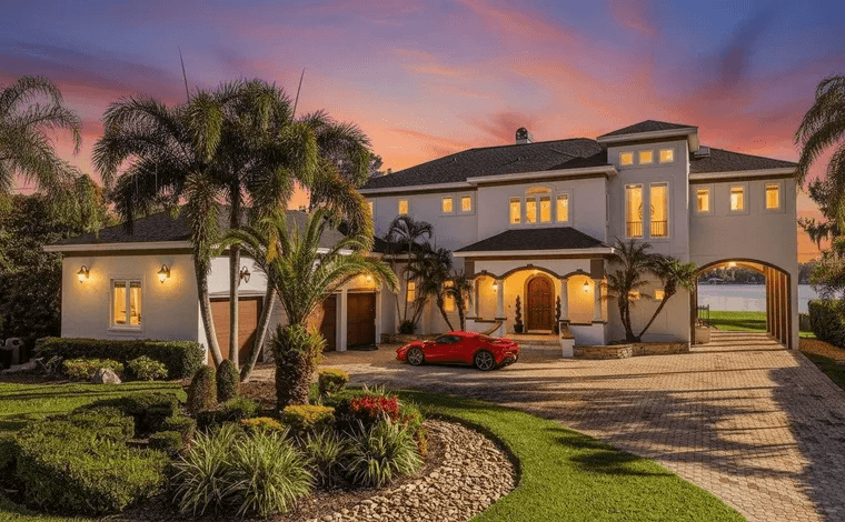 Florida home photographed at twilight with warm interior lighting and illuminated palms